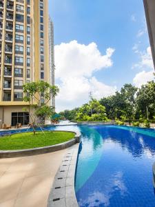 a swimming pool in front of a building at Transpark Cibubur by 21room in Kalimanggis