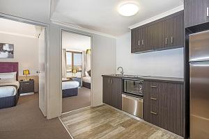 a room with a kitchen and a bedroom at Pavilion Hotel Wagga Wagga in Wagga Wagga