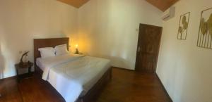 a bedroom with a large white bed in a room at Balee kayuu in Gili Gede