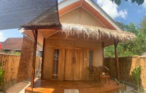 a small house with a straw roof at Balee kayuu in Gili Gede