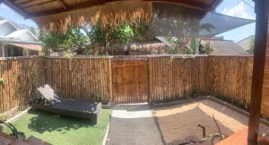 a backyard with a bench and a wooden fence at Balee kayuu in Gili Gede