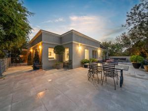 a patio with tables and chairs and a house at Via Bella Vista in Wangaratta
