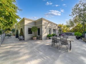 a patio with chairs and tables and a building at Via Bella Vista in Wangaratta