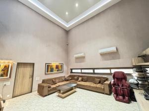 a living room with a couch and a table at Manav Farmhouse in Olpād