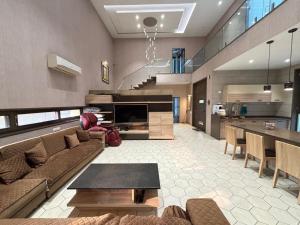 a living room with a couch and a table at Manav Farmhouse in Olpād