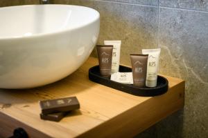 a bathroom counter with a sink and someorativeorativeorativeorativeorativeorativeorative products at Hotel Club Funivia in Aprica +35 photos