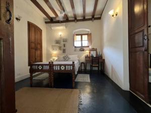 a room with a bed and a table and a window at Gratitude Heritage in Pondicherry +41 photos