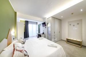 a bedroom with a large white bed and a desk at Hotel Club Funivia in Aprica