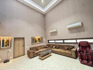 a living room with a couch and a table at Manav Farmhouse in Olpād
