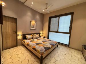 a bedroom with a bed and a large window at Manav Farmhouse in Olpād