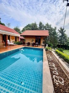 a swimming pool in front of a house at Bella Vista Khao yai in Ban Muak Lek Nai