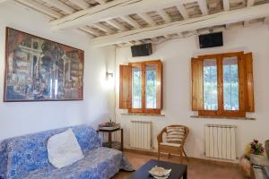 a living room with a blue couch and windows at Alloggi degli Artisti in Case Selva Grande