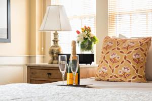 a bed with a bottle of champagne and two glasses at Brass Key Guesthouse Adults Only in Provincetown