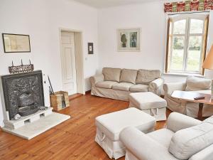a living room with white furniture and a fireplace at Gutshaus Glowitz in Glowitz