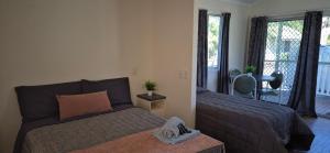 a bedroom with two beds and a desk and window at Gday Parks Emerald in Emerald