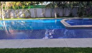 a swimming pool with blue water in a yard at VILLA REAL lll YAUTEPEC in Yautepec de Zaragoza