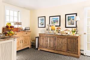 a kitchen with wooden cabinets with fruit on it at Brass Key Guesthouse Adults Only in Provincetown