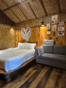 a bedroom with a bed and a couch at Lombok Rice Terracce Glamping in Tetebatu