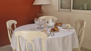 a white table with white chairs and a table with food on it at au fil de l'oust in Rohan