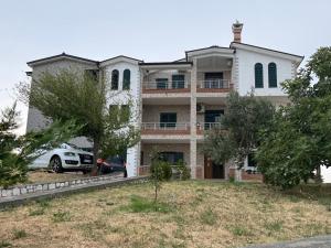 a house with a car parked in front of it at Hotel Restorant Anxhelo in Draç