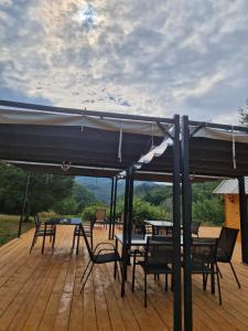 a patio with a table and chairs under an umbrella at Firiza Nature Lodges in Baia Mare +7 photos