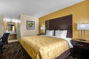 a hotel room with a large bed and a desk at Quality Inn West Fort Worth in Fort Worth +35 photos