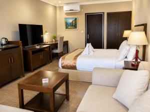 a hotel room with a bed and a couch at Plaza Hotel in Dili +19 photos