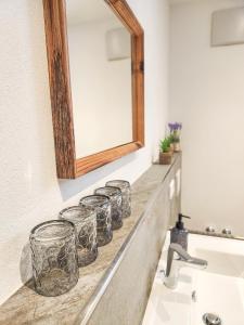 a bathroom counter with a mirror and a sink at Ferienwohnung auf dem Stroblhof in Polling