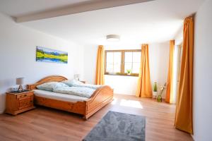 a bedroom with a bed and a wooden floor at Ferienwohnung auf dem Stroblhof in Polling
