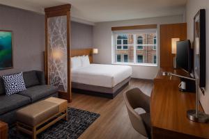 a hotel room with a bed and a couch at Hyatt Place Sumter/Downtown in Sumter