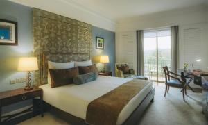 a hotel room with a large bed and a desk at Villa Rosa Kempinski in Nairobi