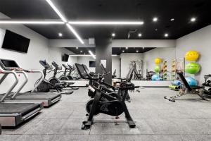 a gym with treadmills and exercise bikes in a room at Grayson Hotel in New York