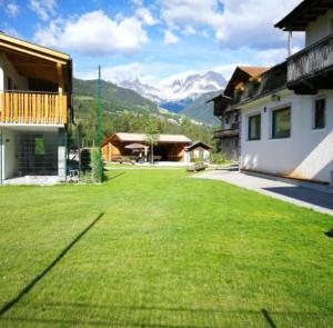 a large grassy yard with mountains in the background at Manötscherhof in Tires
