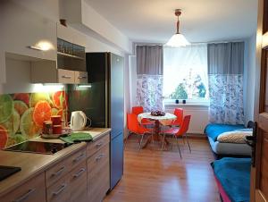 a kitchen and dining room with a table and chairs at Leśny Domek in Bystrzyca Kłodzka