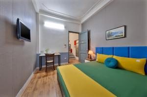 a bedroom with a yellow and blue bed and a desk at Hanoi Sihouse Eco in Hanoi +12 photos