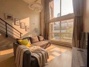a living room with a couch and a large window at The Urban Lofts in Vancouver