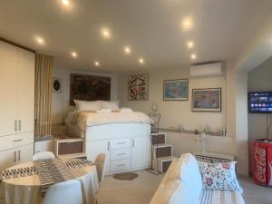a bedroom with a bed and a table and chairs at Amfiteatriko Studio Sea View Oropos Attiki in Kalamos