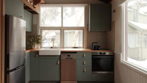 a kitchen with green cabinets and a window at Burramys in Dinner Plain