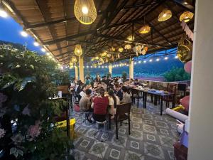 a group of people sitting at tables in a restaurant at Rice Fields Mountain Homestay in Vũ Lâm