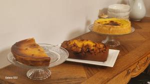 a table with three different types of cakes on plates at au fil de l'oust in Rohan