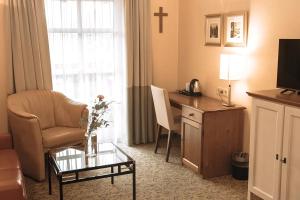 a living room with a chair and a desk with a tv at Aparthotel Alter Weißbräu in Bad Birnbach