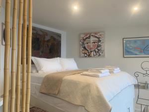 a bedroom with a bed and a painting on the wall at Amfiteatriko Studio Sea View Oropos Attiki in Kalamos