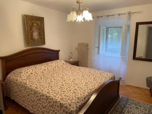ein Schlafzimmer mit Bett, Fenster und Kronleuchter in der Unterkunft Nona Katica in Boljun