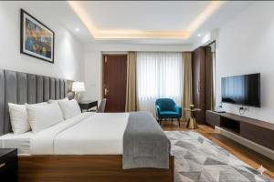 a hotel room with a bed and a flat screen tv at Hotel Royal Green - Green Park Metro in New Delhi