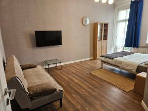 a living room with two beds and a flat screen tv at Blu Apartament in Strzelno