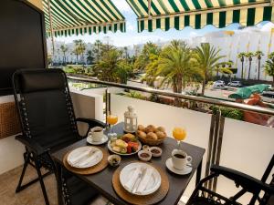a table with food and drinks on a balcony with a view at Solymar Premium Apartment in Playa del Ingles