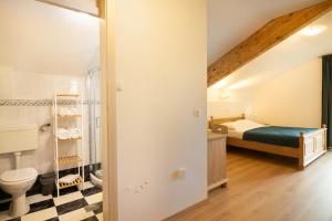 a bathroom with a bed and a toilet in a room at Green Escape garni hotel in Postojna