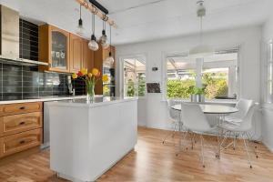 a kitchen with a white island and a table at Villa in Skurup in Skurup