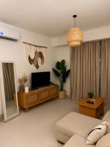 a living room with a couch and a television at Marassi- Faya Residence in El Alamein