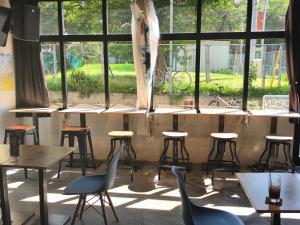 a row of tables and chairs in a room with windows at Tokyo Guest House Ouji Music Lounge in Tokyo